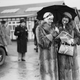 Two women race fans shelter from the rain at Brooklands, 1936.